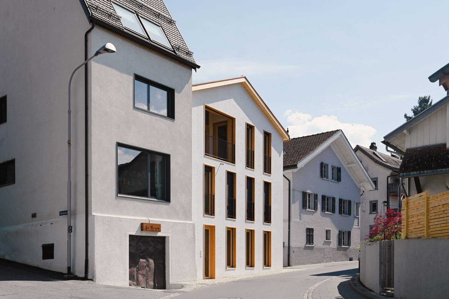 Neubau Brändli Gioia Architekten in Igis, Einbindung des Mehrfamilienhauses mit Gewerbe in der Dorfstruktur